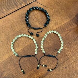 2 gold, 1 black bracelet